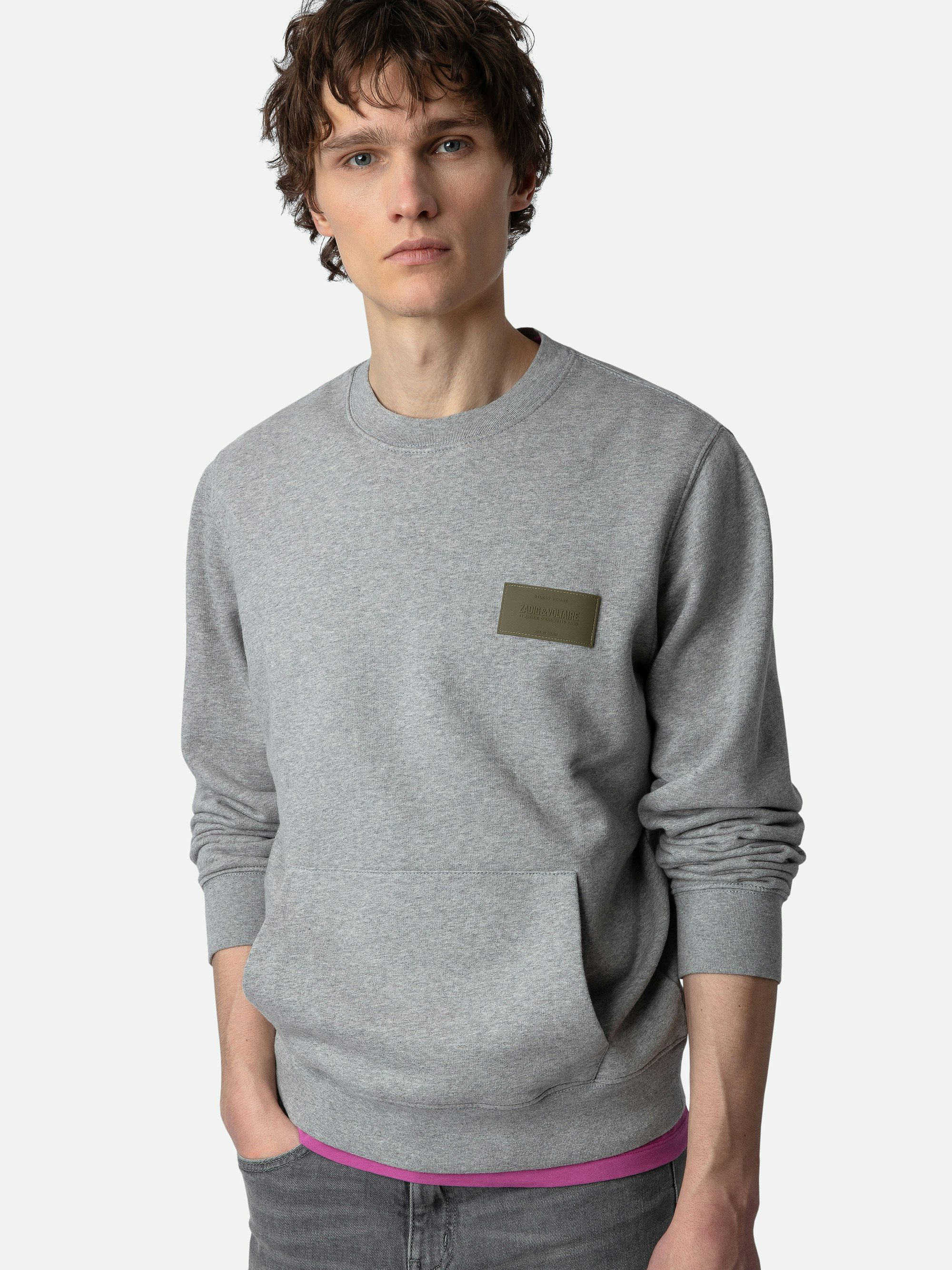 Sudadera Aime - Sudadera en color gris jaspeado con mangas largas, cuello redondo y parche decorativo en el pecho.
